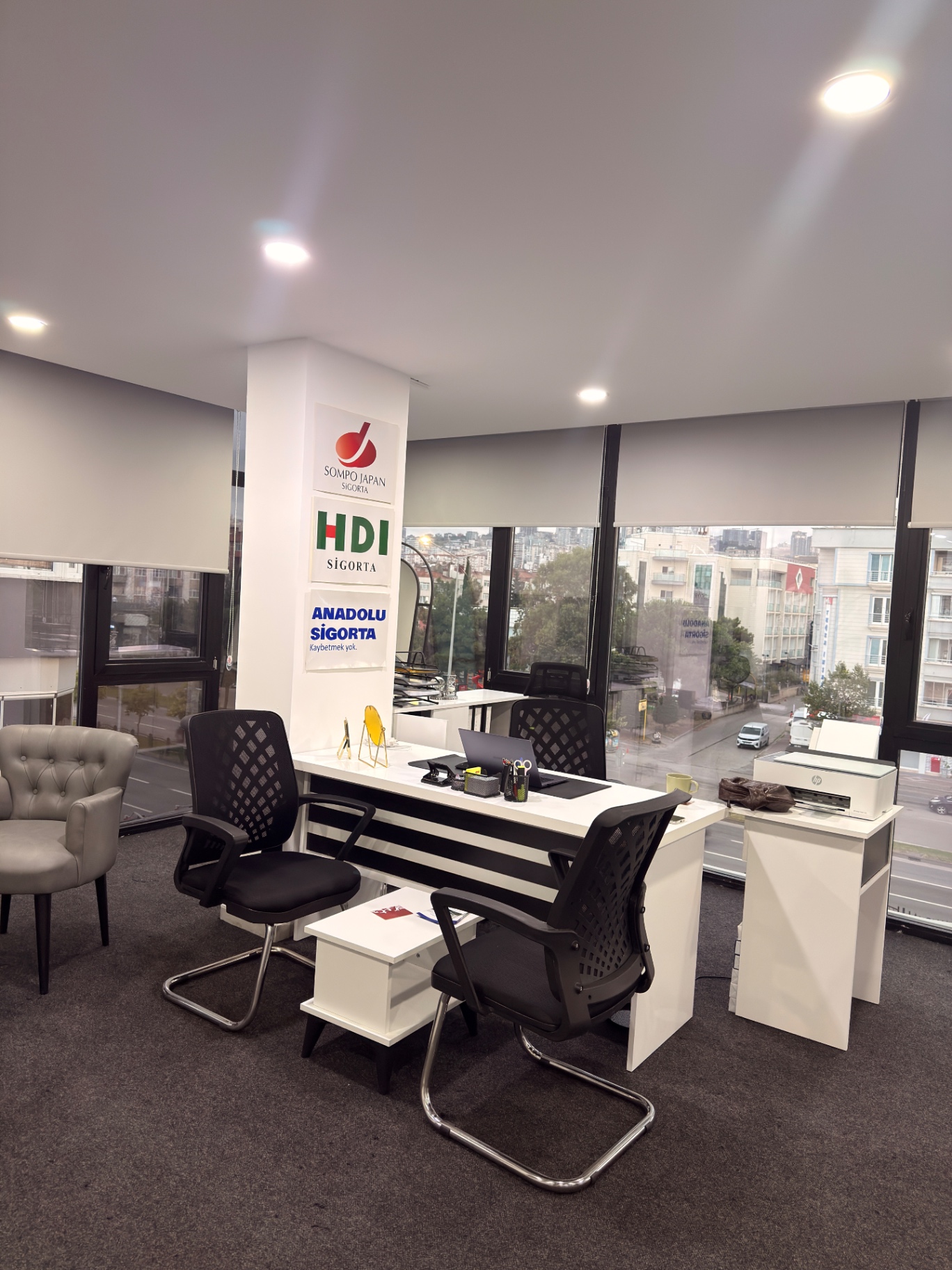 Ofis köşesinde yazıcı, danışma masası ve koltuk