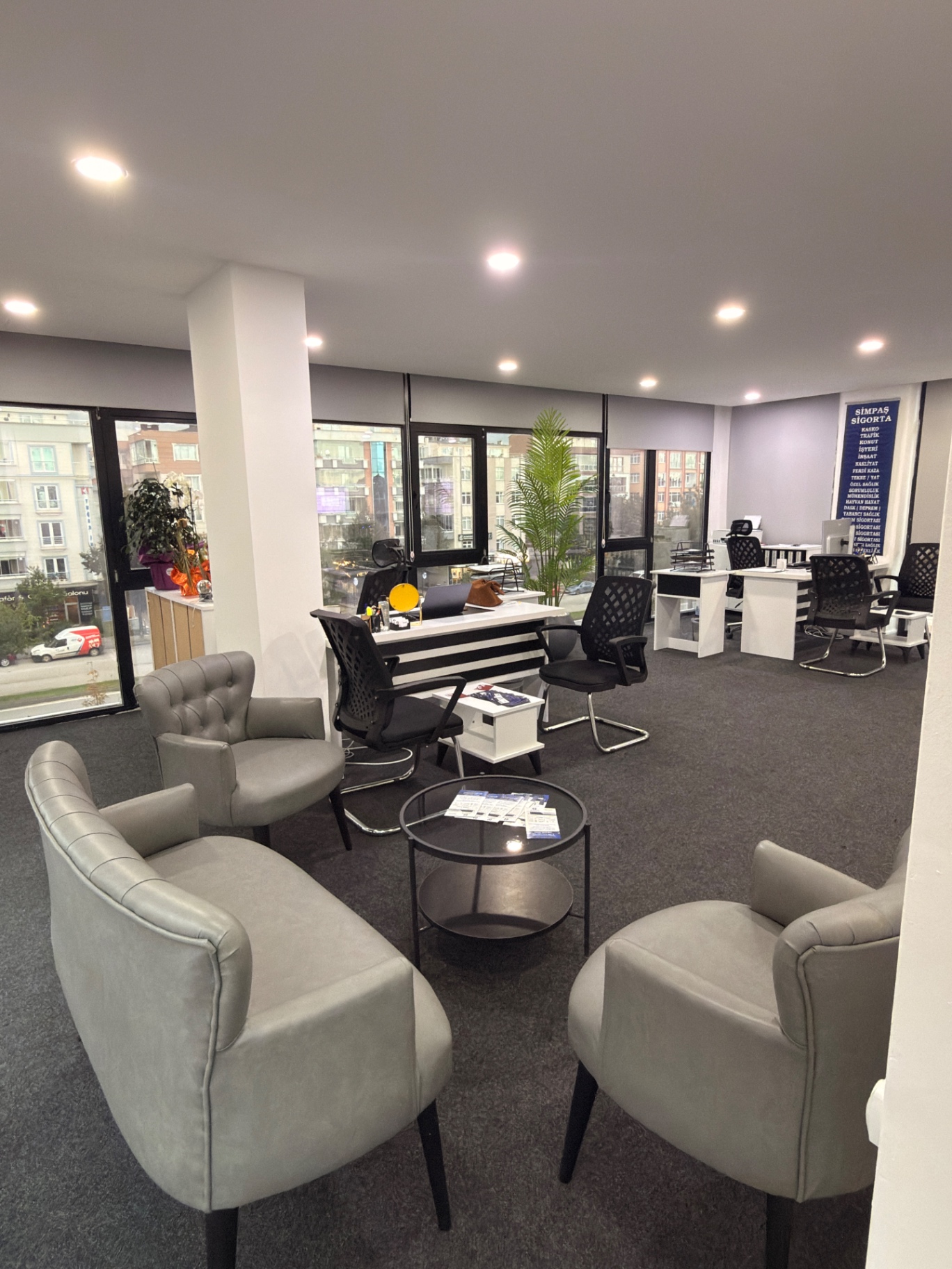 Ofis içinde koltuklu karşılama alanı ve cam sehpa