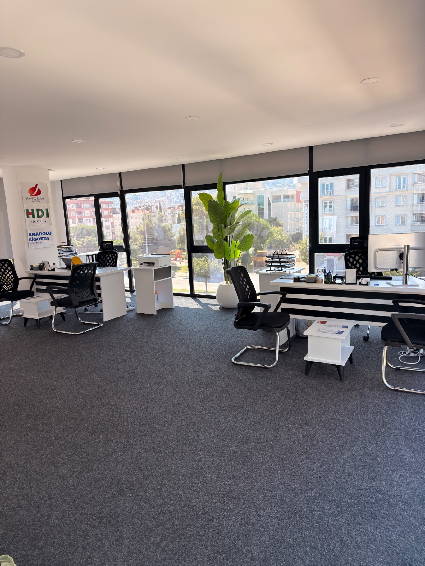 Pencere önünde iki çalışma masası ve ofis sandalyeleri